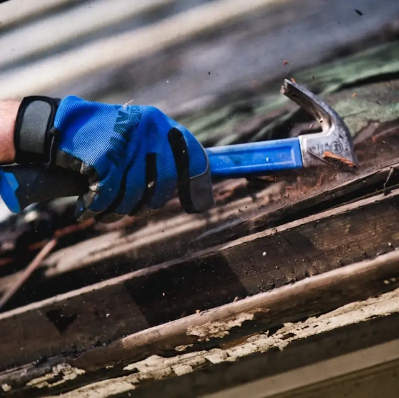 Shingle Replacement Conroe TX 1 Roofer removing damaged wood and old material from a shingle repair area on a Conroe, TX home